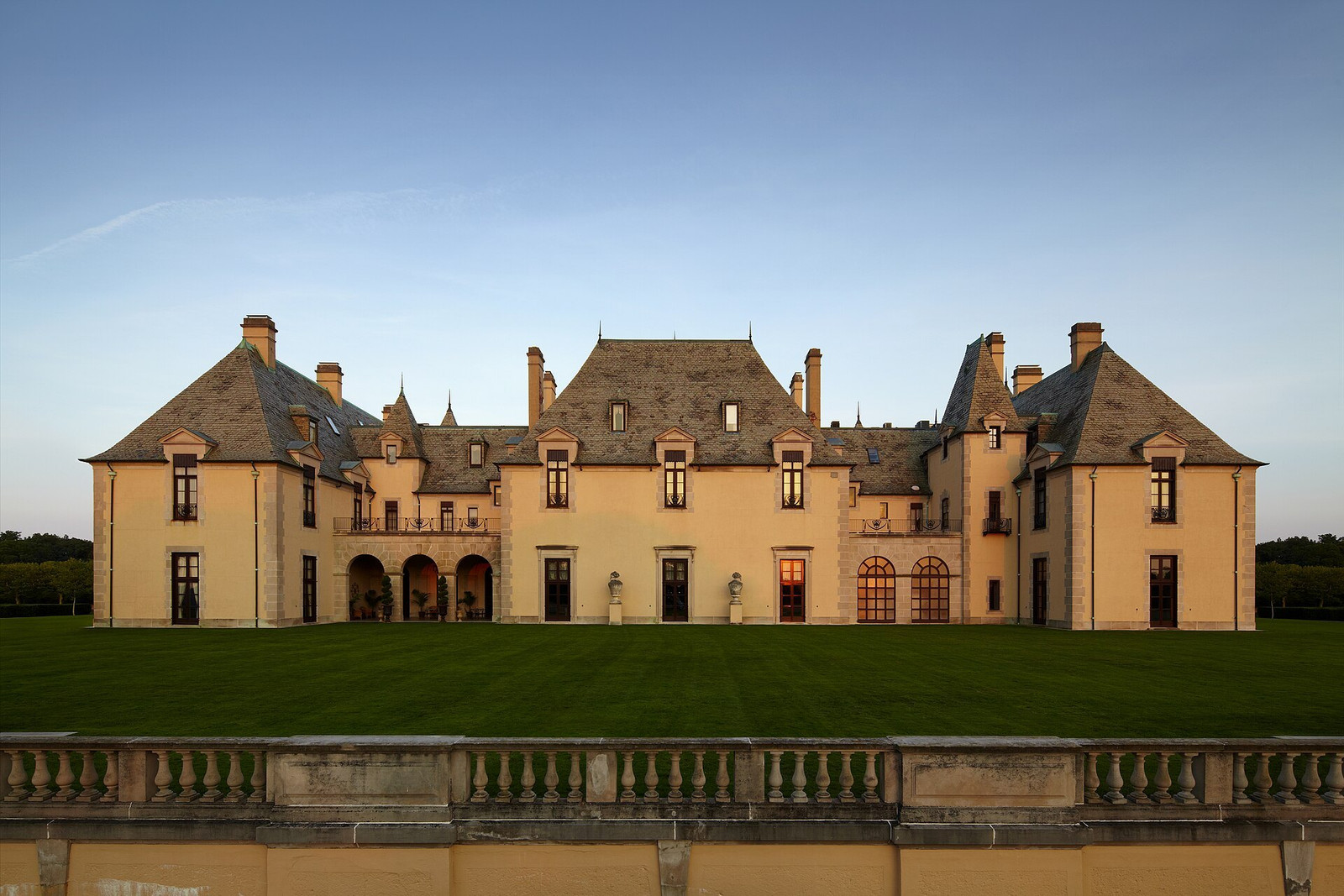 Secondary elevation of Oheka Castle facing a broad lawn and stone balustrade