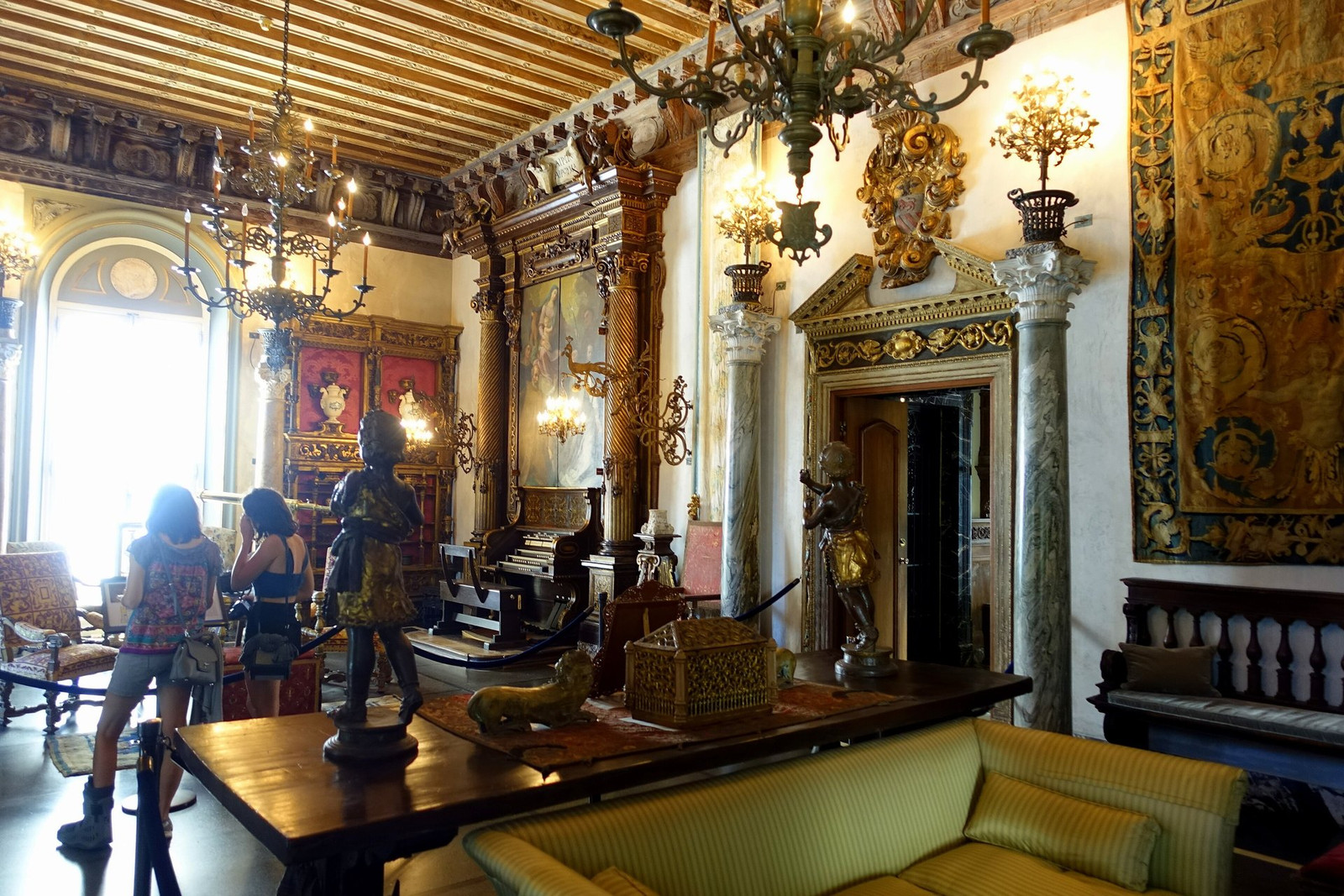 Vizcaya living room with carved stone, tapestries, paintings, and upholstered seating